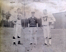 Coach Ferzacca ca. 1960: Coach Ferzacca Standing with Players #81 and #17