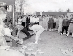 Beta Bunyan Ball: Crowd Watching Two Men Use Crosscut Saw to Cut Log