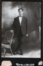 Man with Bowtie Leaning on Chair