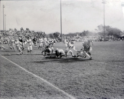 Football ca. 1960: Action Photo of #47 Running with Ball and #84 Trying to Tackle Him