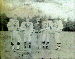 Coach Ferzacca (center) ca. 1960: Coach Ferzacca Standing Posed with Players #38, #42, #21, and #45