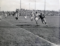 Football ca. 1960: Action Photo of Player #79 Running with Ball and Player Trying to Block