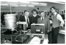 Group of Men Looking at Monitor next to Water System (Part of the NMU Historic Photographs Collection)