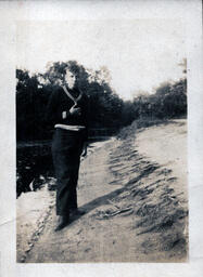 Boy Standing on River Bank