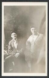 (020-002) Two Men Posing in front of Pipes