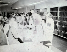 Summer Registration 1961: Small Group Around Table Registering