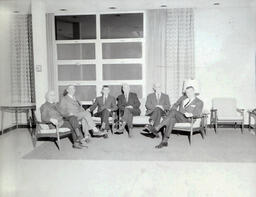 NMC Alumni Basketball 1960-61: Six Men in Suits Sitting in Chairs