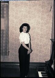 (167-001) Delores Dobbek Posing next to Piano