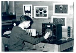 Student Twisting Knobs on Electronic Equipment (Part of the NMU Historic Photographs Collection)