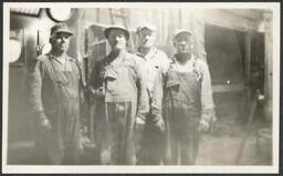 (020-004) Four Men Posing in front of Gauges