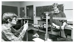 Two Students Working on Experiment with Telescope and Scale (Part of the NMU Historic Photographs Collection)