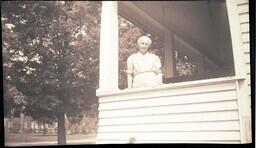 (043-006) Older Woman Standing on Porch