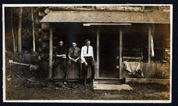 Three Men on Railing of Log Cabin