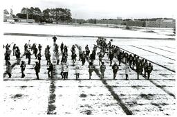 Marching Band Practicing in Snowy Field across from Marquette Armory and Dormitories (Part of the NMU Historic Photographs Collection)