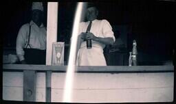 (008-013) Two Men Standing Behind Counter