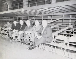 NMC - MSU Basketball Coaches and Officials February 4, 1961: Overexposed Photo of Men Sitting on Sideline of Basketball Court