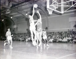 (586-01) Basketball--NMC vs. St. Norbert Feb. 24, 1961: College Basketball Players by the Net