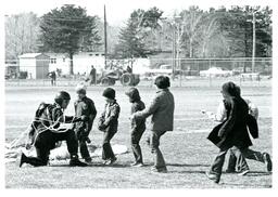 Man with Parachute Kneeling on Ground Speaking to Group of Children (Part of the NMU Historic Photographs Collection)