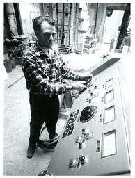 Man Turning Wheel on Panel of Electronic Equipment (Part of the NMU Historic Photographs Collection)