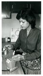 Woman Setting Up Sample on Microscope (Part of the NMU Historic Photographs Collection)