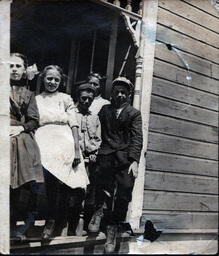 Children Leaning off of Front Porch