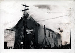 Crowd Gathered as Men Try to Reach Upper Floors of Burning Standard Service Building