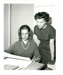 Two Women Look at Piece of Paper (Part of the NMU Historic Photographs Collection)