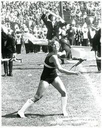 Baton Twirler, Rifle Twirlers, and Color Guard Performing in front of Marching Band (Part of the NMU Historic Photographs Collection)