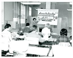 Professor Pointing to Typing Chart (Part of the NMU Historic Photographs Collection)