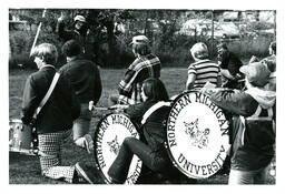 Marching Band Percussion Section Kneeling on Grass while Conductor Speaks (Part of the NMU Historic Photographs Collection)