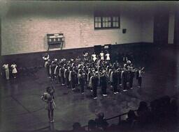 (022-004) Marching Band and Flag Twirler Performing in Gymnasium (1 of 2)