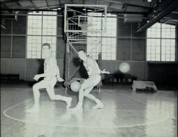 Basketball Teams and Individuals 1959-1960: Two Basketball Players Passing Ball