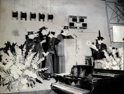 Commencement 1960: View of Open Piano, Speaker, and Several Men on Stage