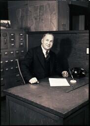 (122-007) Charlie Hill at Desk