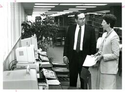 Two People Talking Next to Computers (Part of the NMU Historic Photographs Collection)