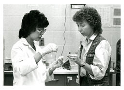 Two Women Discuss Sample in Lab (Part of the NMU Historic Photographs Collection)