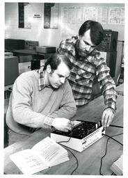 Two Men Working with Circuit Box (Part of the NMU Historic Photographs Collection)