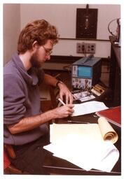 Student Taking Notes Next to Electronics (Part of the NMU Historic Photographs Collection)