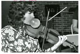 Student Blowing Gum Bubble while Playing Violin (Part of the NMU Historic Photographs Collection)