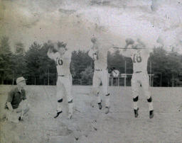 Coach Ferzacca (kneeling) ca. 1960: Coach Ferzacca Kneeling Next to Players #16, #17, and #18 Who Are Throwing Footballs