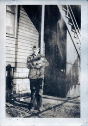 Boy Cradling Kitten Under Staircase