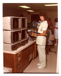 Doctor Checks Monitors and Binder (Part of the NMU Historic Photographs Collection)