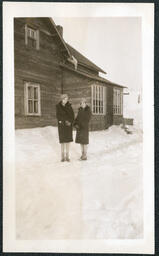 Two People Standing Outside Home