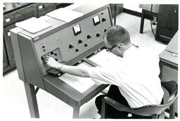 Man Twisting Knobs on Machine (Part of the NMU Historic Photographs Collection)