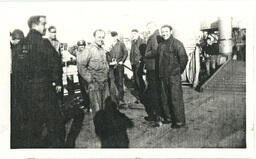 Group of Men in Uniforms with Machinery in Background