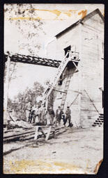 People Posing next to Tall Building (Shafthouse?)