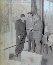 Alumni Spring Roundup--Lansing, Michigan 1961: Three Men Standing Together Looking at Something