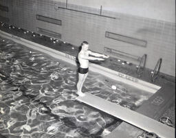 NMC Swimming Team 1961: Man Standing on Diving Board with Arms Raised