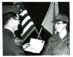 Man in Military Uniform Handing a Piece of Paper to a Woman in a Military Uniform (Part of the NMU Historic Photographs Collection)