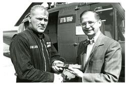 John X. Jamrich Handing Award to Sinclair in Front of Helicopter (Part of the NMU Historic Photographs Collection)